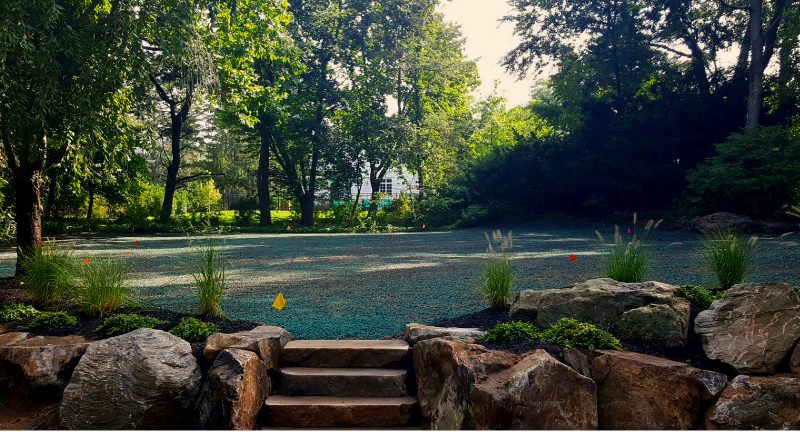 Stone steps lead to a large, landscaped area that has recently been planted with grass seed