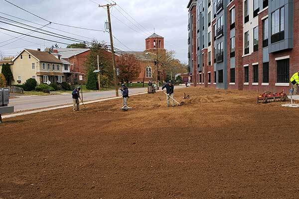 Landscapers grading a commercial property and getting it ready for sod.