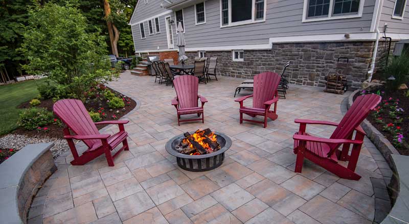 A curved circular patio with seating wall and firepit