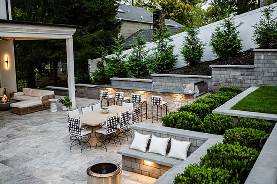 Custom patio design and installation with outdoor kitchen, bar, dining, and entertaining spaces.