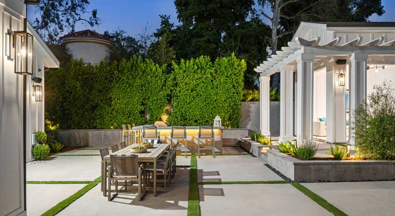 Elegant outdoor dining setup with bar seating and pergola structure