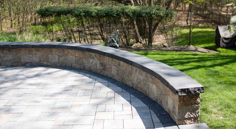 An inviting garden scene with curved patio and seating wall