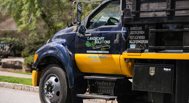 Landscape Solutions branded work truck parked in a community setting, ready for commercial landscaping service in New Jersey.