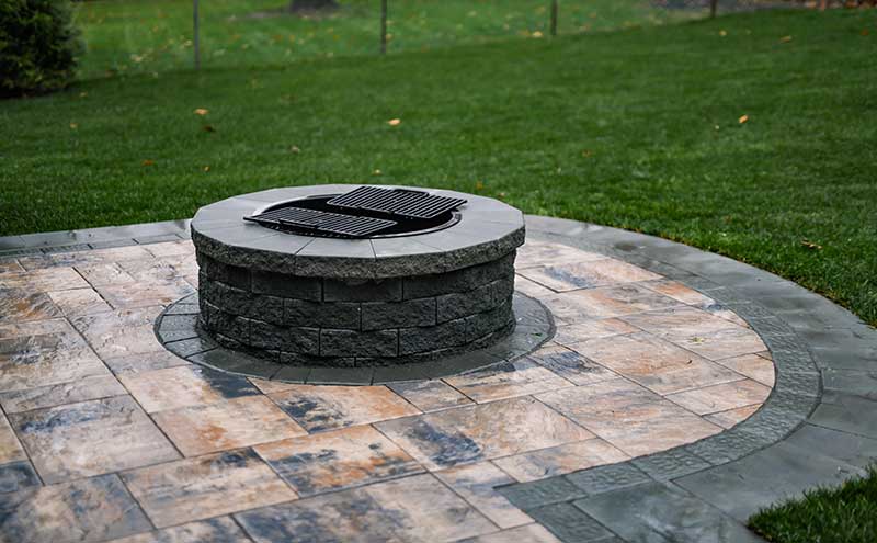 Artistic curved paver patio design with a firepit