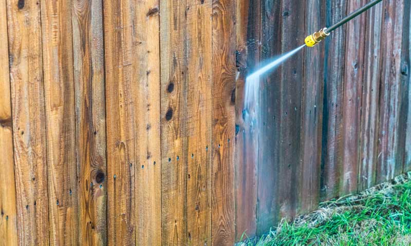Power washing a wooden fence to make it look like new