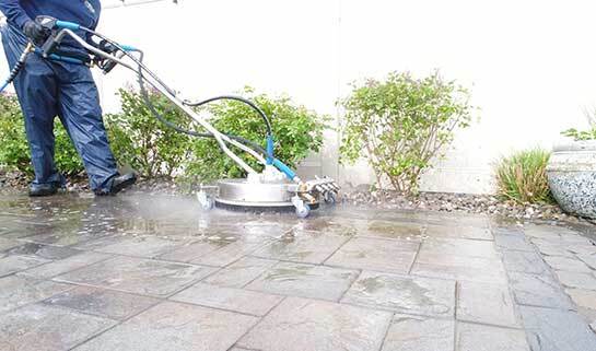 Landscaper power washing a paver patio in NJ