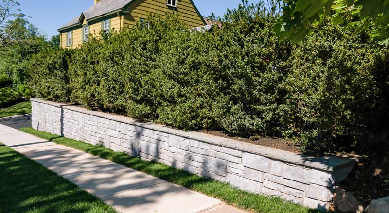 A stone retaining wall for a sloped front yard