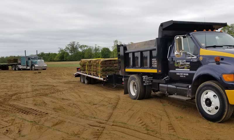 Landscape Solutions trucks delivering pallets of sod