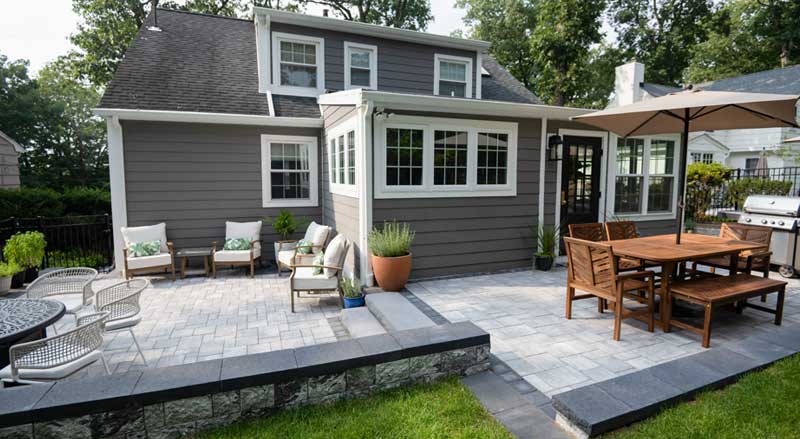 Backyard patio with separate dining and lounge areas for entertaining and relaxing in NJ outdoor living spaces.