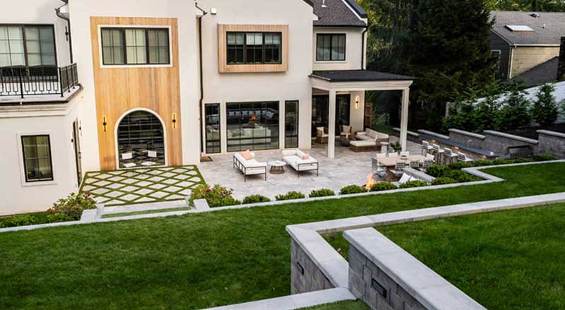 Modern backyard landscape with patio, lawn, and structured planting beds, highlighting plant choices that complement outdoor living spaces.