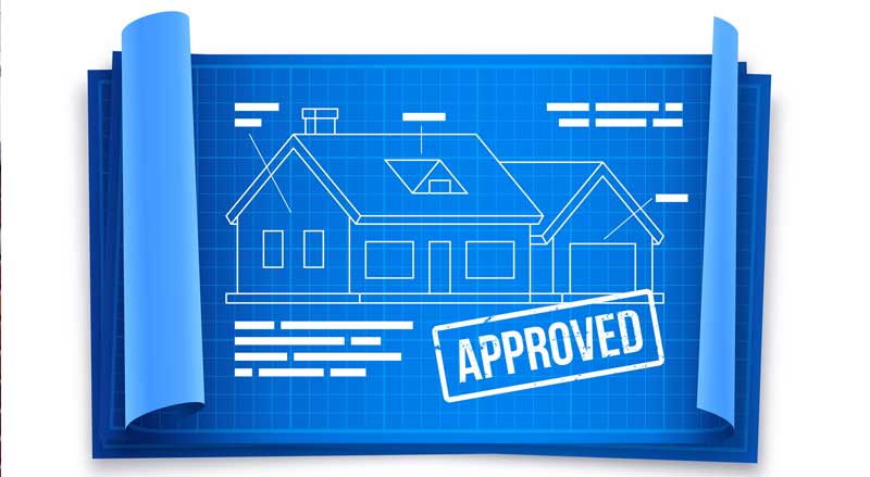 Residential construction blueprint stamped approved, representing required permits before landscaping work