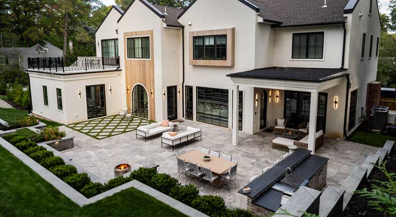 A beautiful wide shot of a backyard bluestone patio with a lush green yard